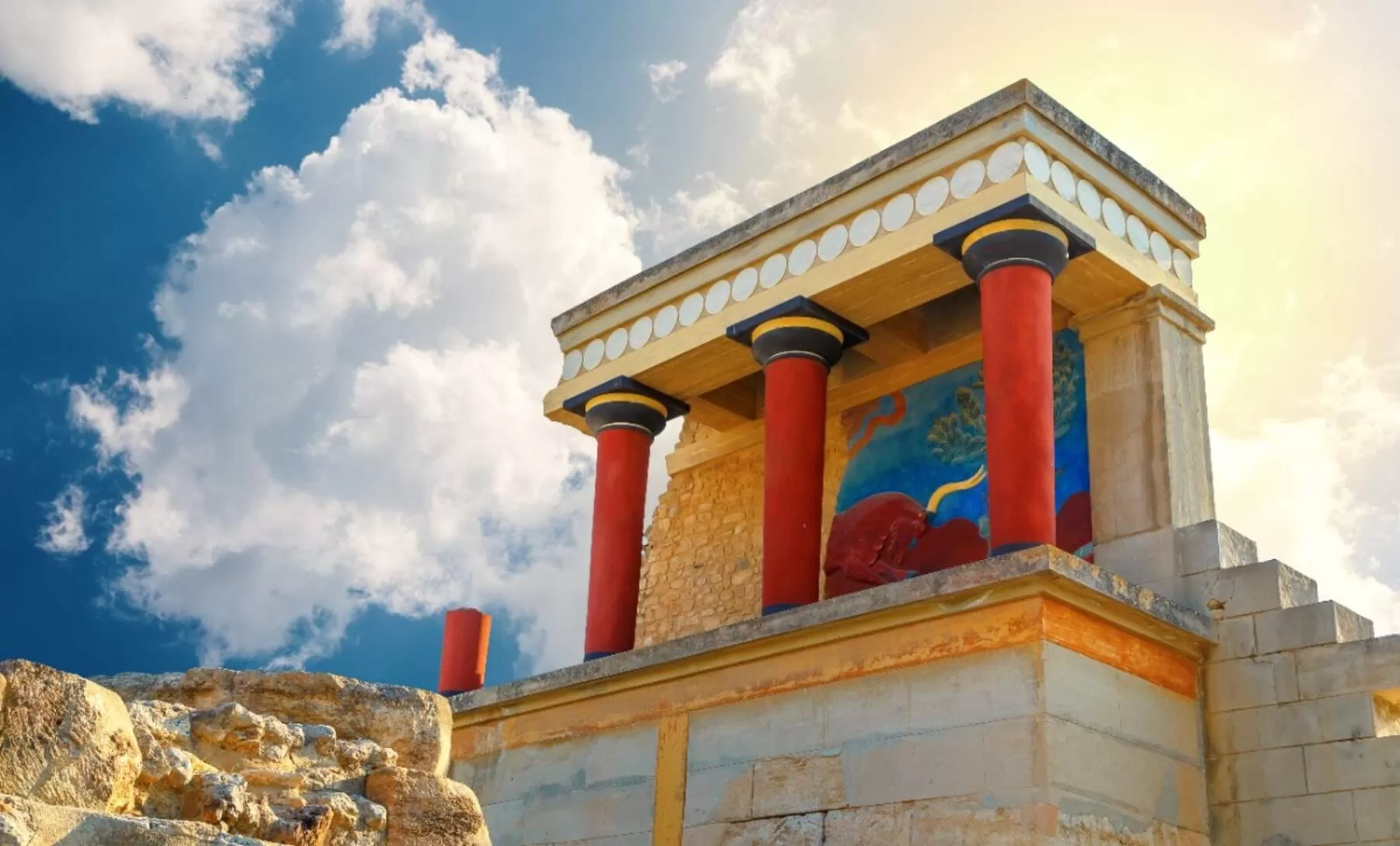 Palace of Knossos in Crete with red columns and Minoan fresco under the sun.