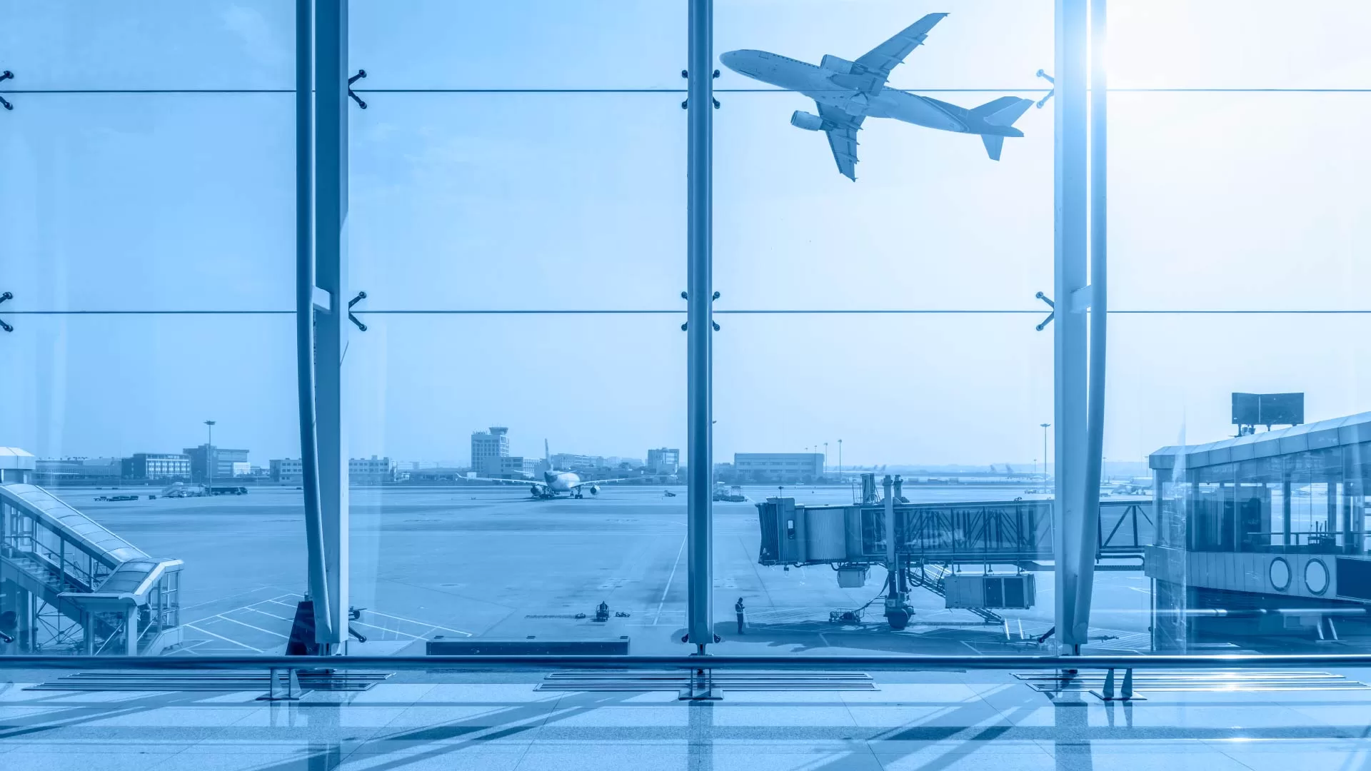 Airplane taking off from the airport, as seen through the terminal window, symbolizing air travel for tourists.